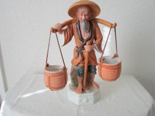 Chinese Man Figurine Carring Porcelain Pots photo