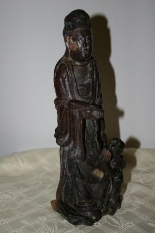 Old Chinese Statue Of Kwan Yin With A Child. photo