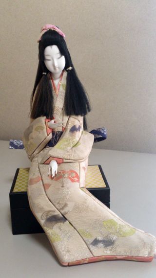 A Japanese Geisha Kimono Doll Sitting photo