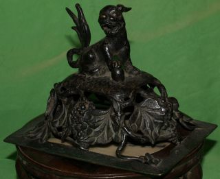 Stately Chinese Antique Iron Cover; Dog Sits Atop Finely Crafted Grape Display photo