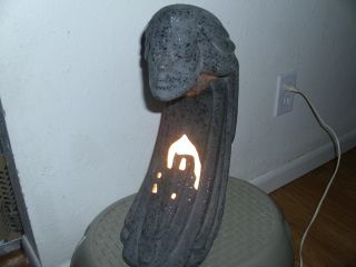 Lamp Of A Woman With A House Lit Up Underneath. photo