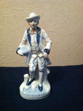 Aristocrat Holdin Basket Sitting On Tree Stump Porcelain Figurine photo