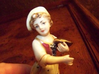 Antique Hand Painted Porcelain Figurine Of Girl Holding Basket Of Grain. photo