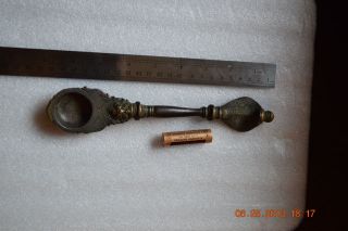 A Bronze Spoon With A Handle In The Shape Of A Snake Head photo