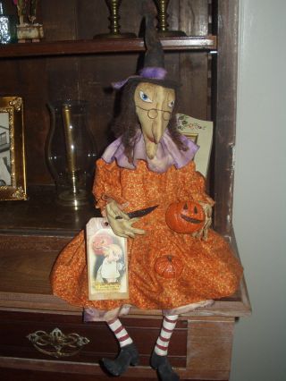 Primitive Witch Carving A Halloween Pumpkin photo