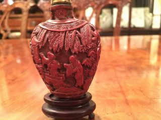 A Chinese Qing Dynasty Carved Cinnabar Snuff Bottle With Stand. photo