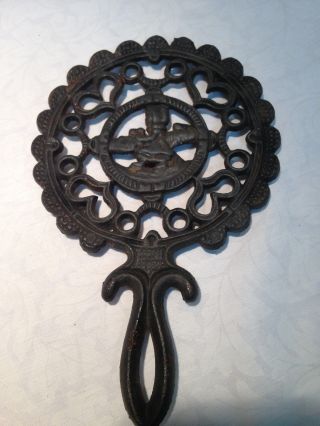Antique Cast Iron Footed Round Trivet With Hearts And Child Design photo