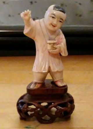 Chinese Little Boy Figurine On Wooden Stand photo